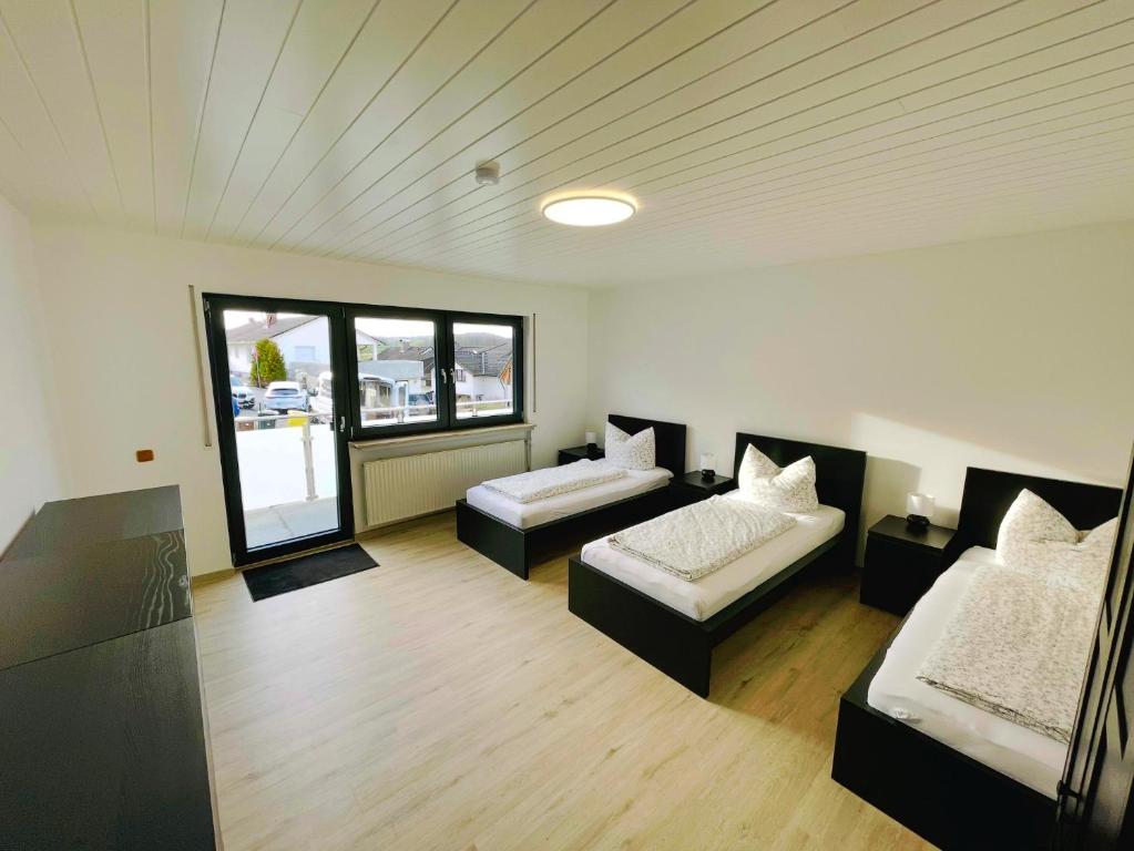 una grande camera con due letti e un divano di Panoramablick Ferien- und Monteurwohnung OG a Mörlenbach