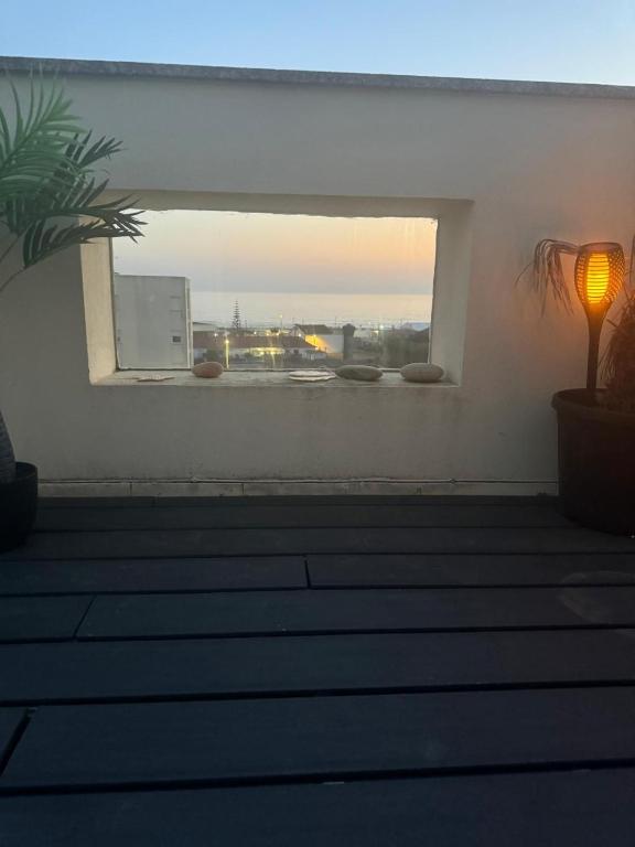 a window in a room with stairs and a lamp at Beautiful duplex with sea view in Vila Praia de Âncora