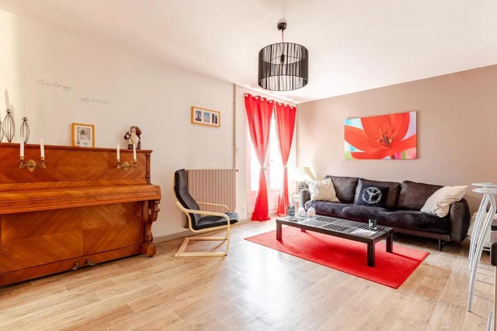 un soggiorno con divano e pianoforte di Maison avec jardin privé à Plaisance-du-Touch a Plaisance-du-Touch