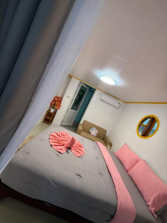 una camera da letto con un grande letto con cuscini rosa di Kaneng Homestaykohpu a Ban Klang