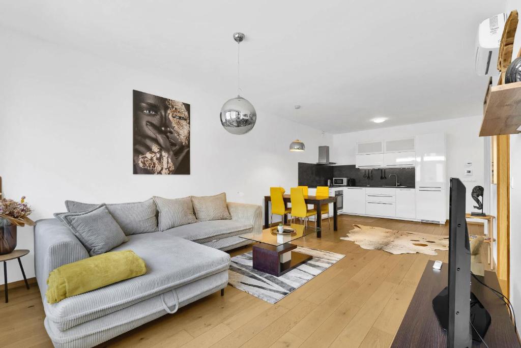 a living room with a couch and a table at Riverside luxury apartment in Bratislava