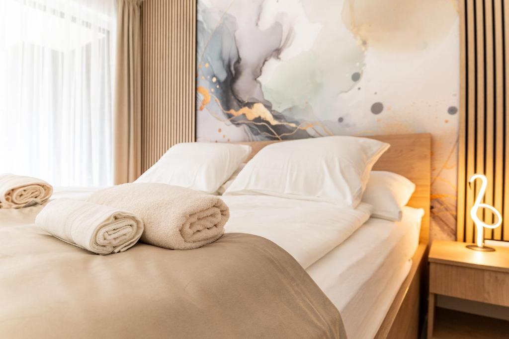 a bedroom with a bed with towels on it at Hajnal Residence Deluxe with Terrace by Mital in Szeged