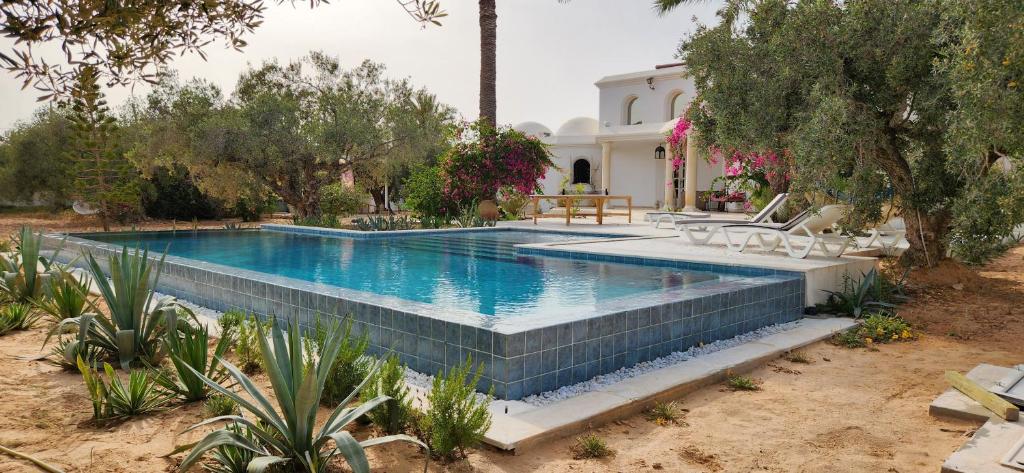 a swimming pool in the yard of a house at Dar 'Villa Blanche' in Djerba
