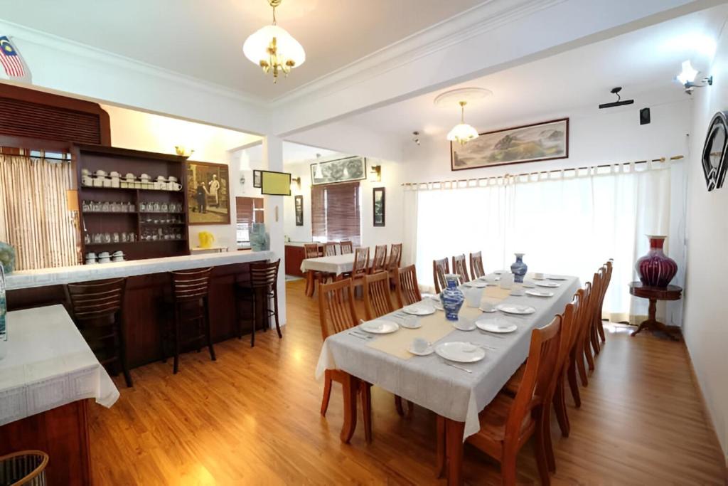 a dining room with a long table and a bar at Holiday Bungalow Suites - Sleeps Up To 26 Pax in Tanah Rata