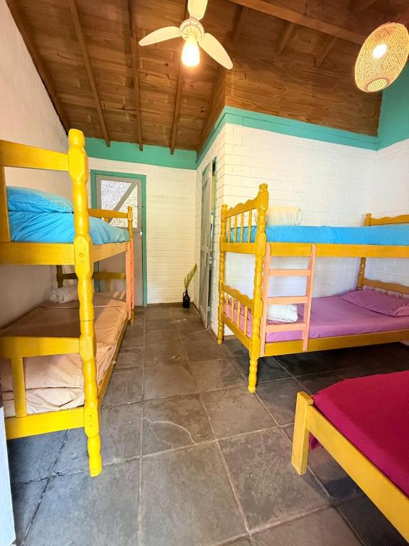 a room with two bunk beds and a ceiling at Hostel Pantera do Rosa in Praia do Rosa