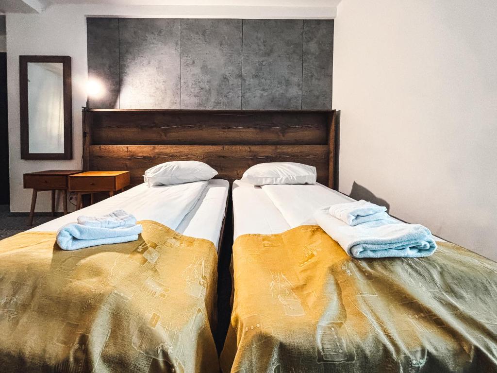 two beds sitting next to each other in a room at Hotel City Center in Braşov