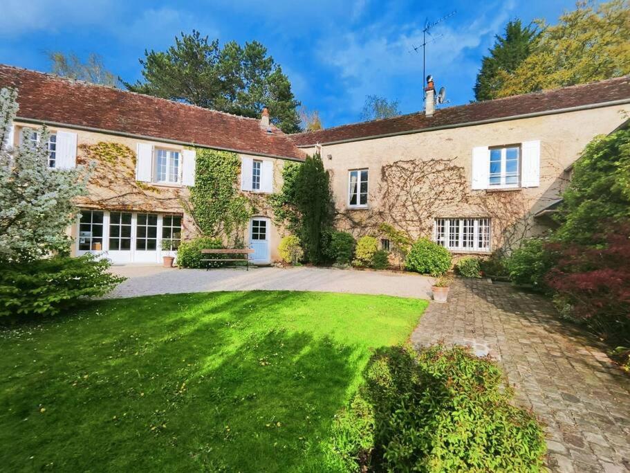 an exterior view of a house with a yard at Idyllic holidays at Domaine de la Biche in Luzarches