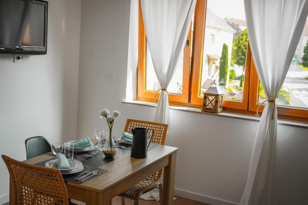 a dining room table with chairs and a window at Logement 3 pers proche Forbach 02 in Folkling