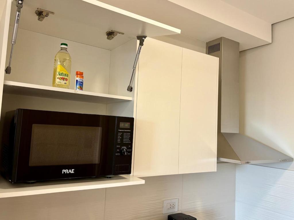a microwave oven in a kitchen with white cabinets at Matrisa Boggiani 805 - Vivelite in Asuncion