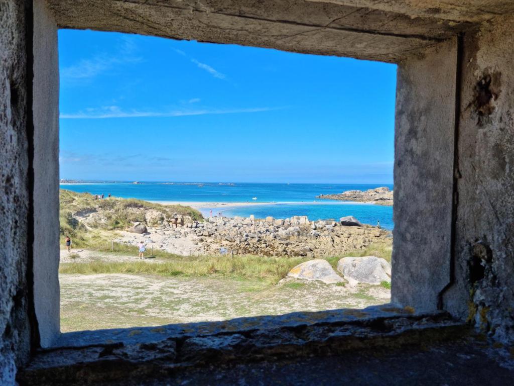 a window view of the ocean from a beach at Villa Mahina - 6 chambres - 12 pers in Cléder