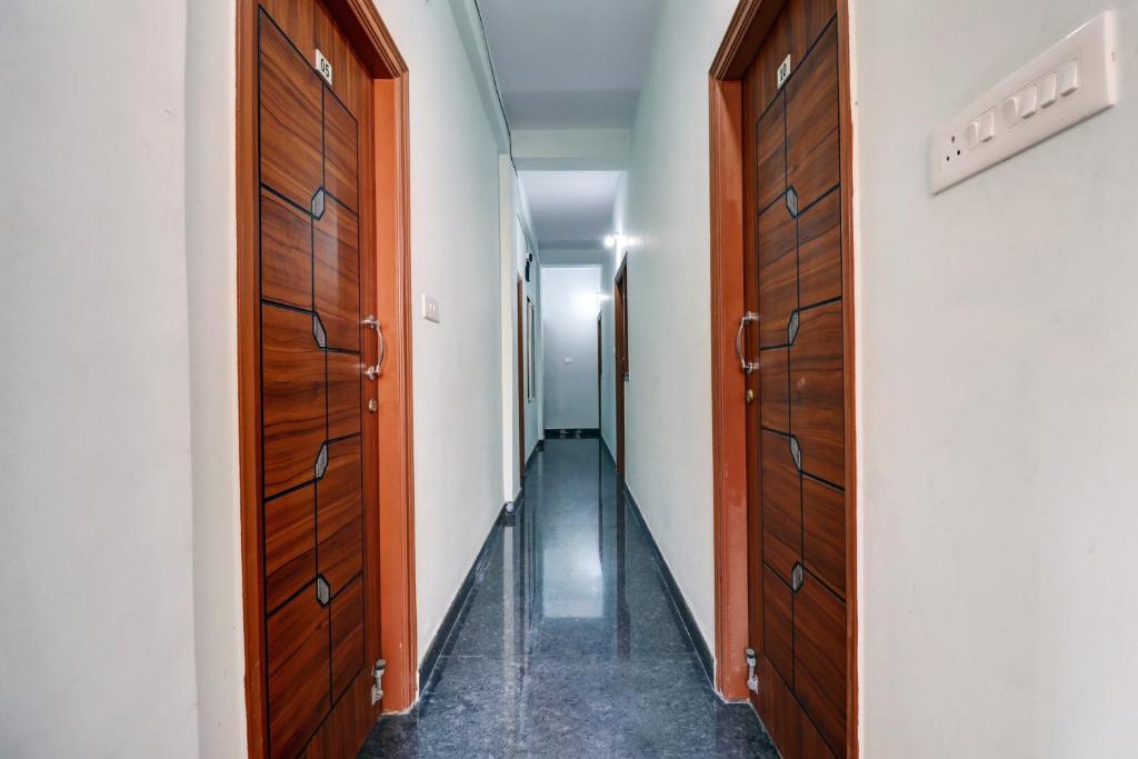 a hallway with two wooden doors and a hallway with a hallway at Super Hotel O PM Hotels in Bengaluru