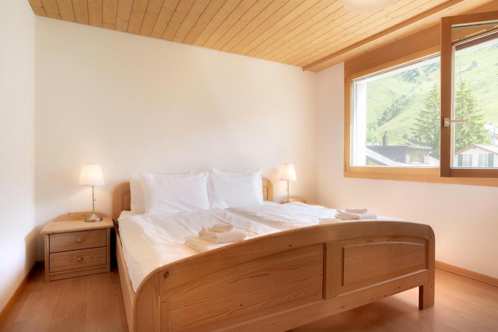 a bedroom with a large bed with a window at Annika Apartment in Andermatt