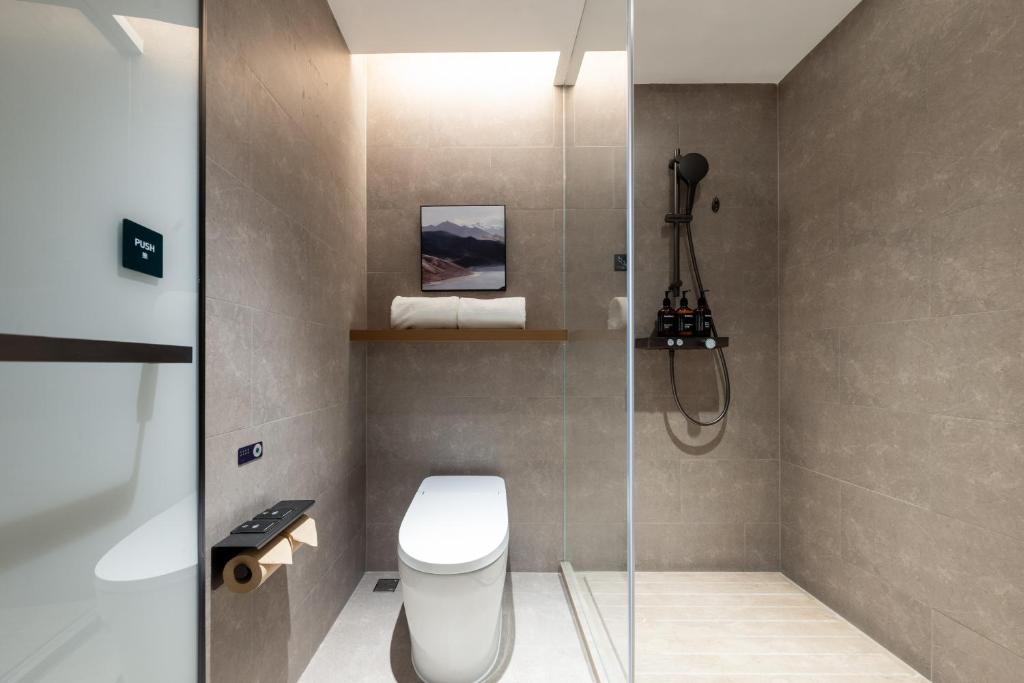 Atour Hotel Suzhou Jinji Lake East Park High-Speed Rail Station في سوتشو: حمام مع مرحاض ودش