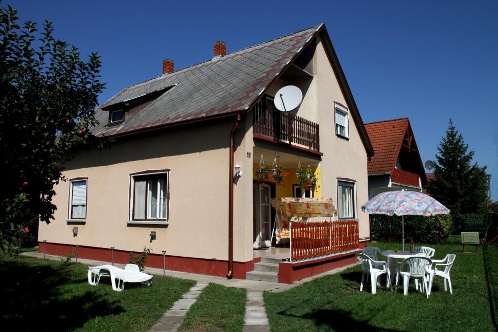 a house with a table and chairs in the yard at Familia Nyaraló 22 in Balatonmáriafürdő