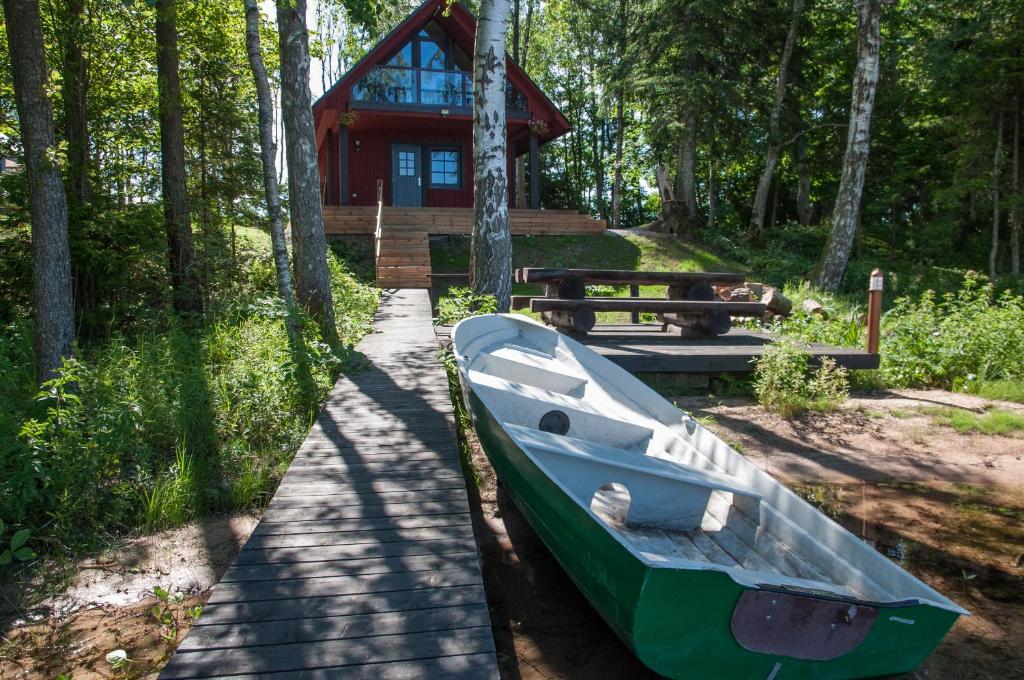 un bateau est garé devant une cabine dans l'établissement Karujärve Camping, à Paiküla