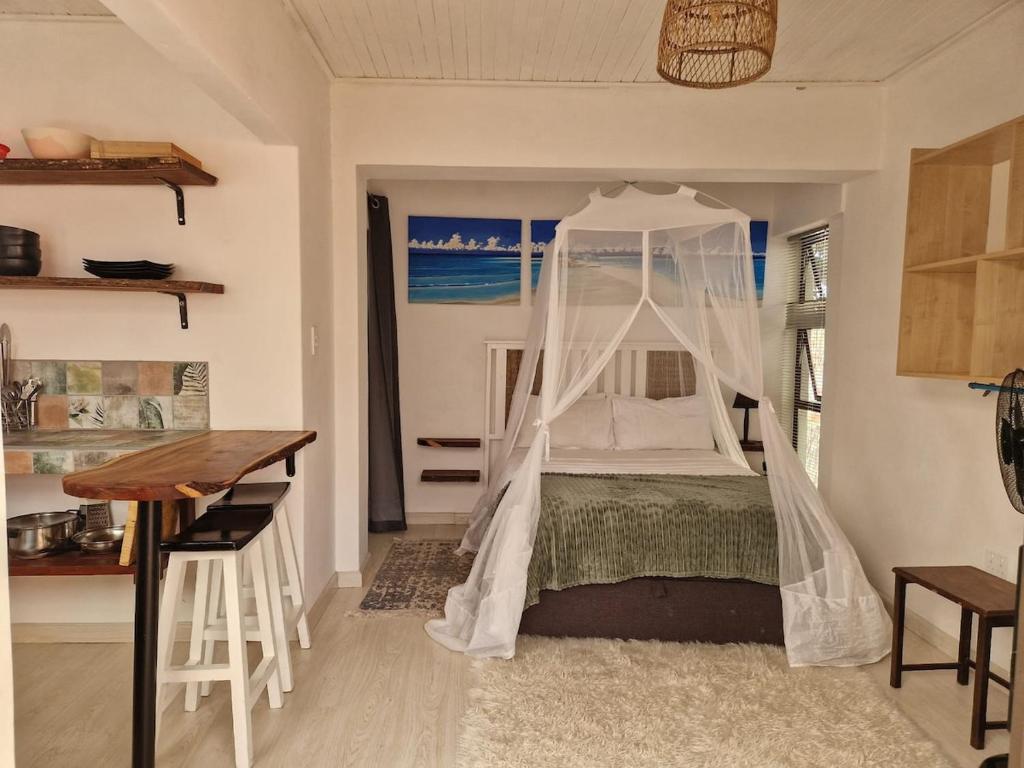 una camera da letto con un letto a baldacchino di The Seabird Cottage a Gqeberha
