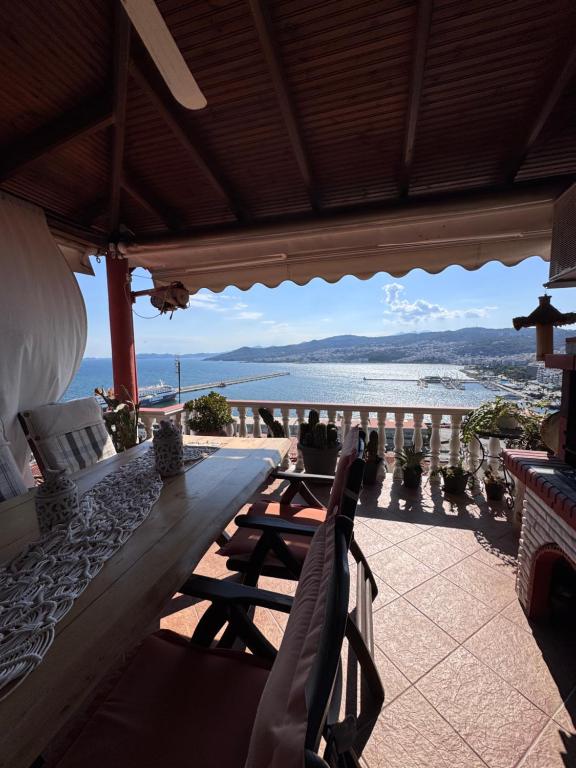 a table and chairs on a patio with a view of the ocean at Saguaro’s home Kavala in Kavála