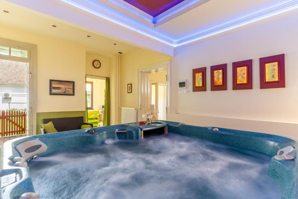 a large bathroom with a tub in a room at Varázsfészek Vendégház in Majs