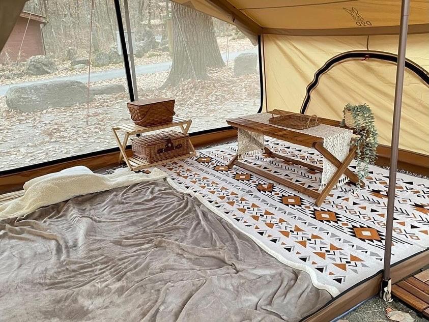 a tent with a bed and a table in it at Bertinus Medieval Lodge Camping in Serra Negra