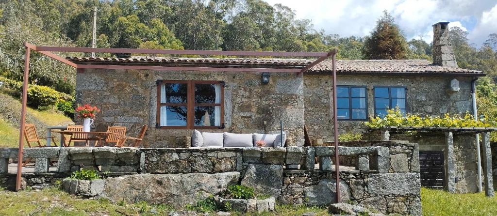 a stone house with a table and chairs in front of it at Casa Gallega Tradicional La Mar in A Guarda