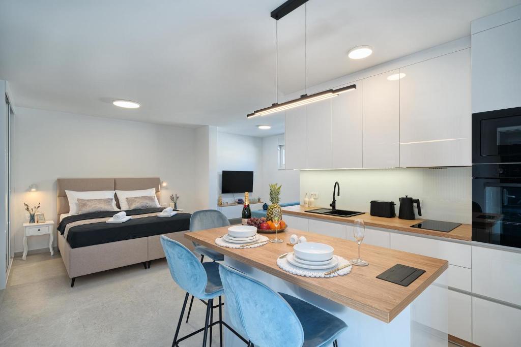 a kitchen and living room with a bed and a table at Mićos Beach Studio with Pool in Slatine
