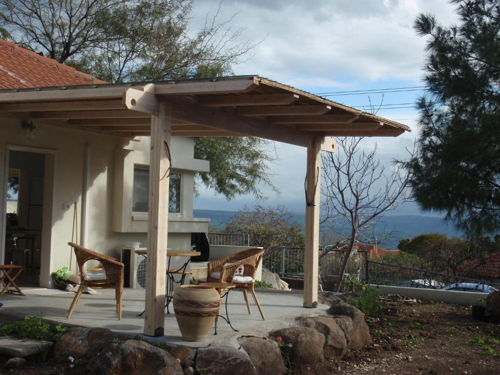 a wooden pergola on a patio in front of a house at Lovely home above the Kinneret in Karkom