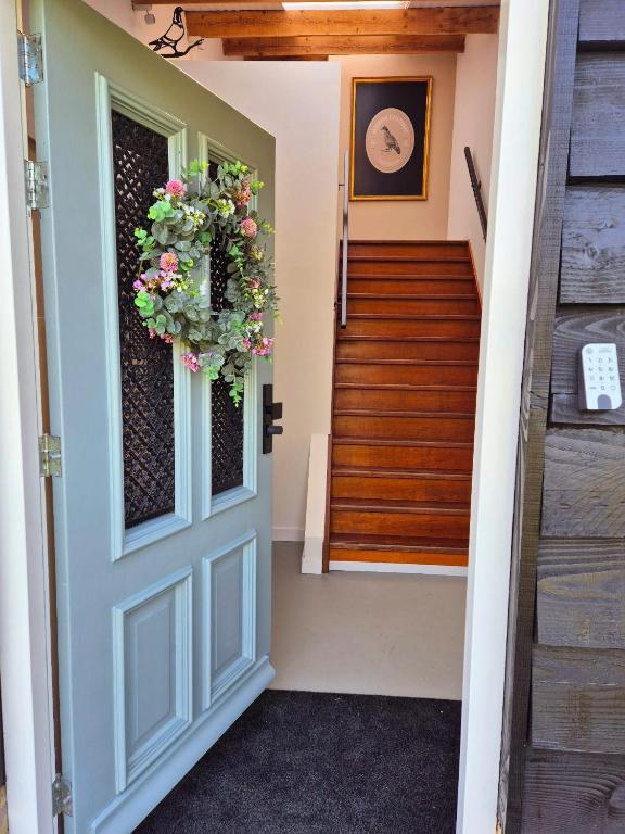 a door leading to a staircase with a wreath on it at Maison Colombe, met airco in Oudesluis