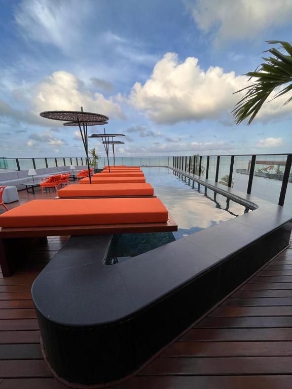 a row of tables with umbrellas on a deck at Flat 410 Luxo com Varanda e Vista Mar l Frente Mar Orla de Cabo Branco I Setai Edition in João Pessoa
