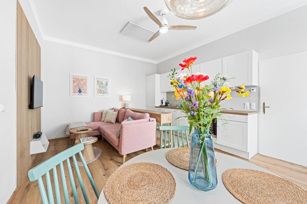 a living room with a table with flowers in a vase at Mamalipa Apartments in Vienna