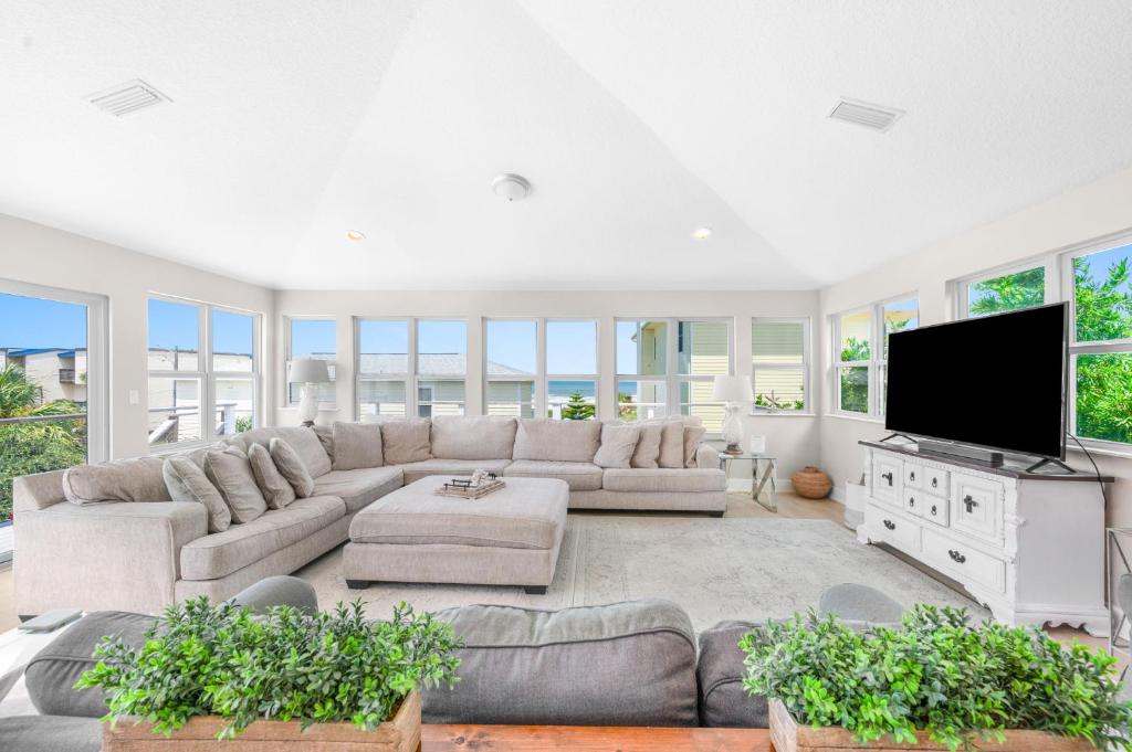 Una gran sala de estar con un sofá y un televisor. en Sea Gem Beach Slp 16 Amenities, en St. Augustine