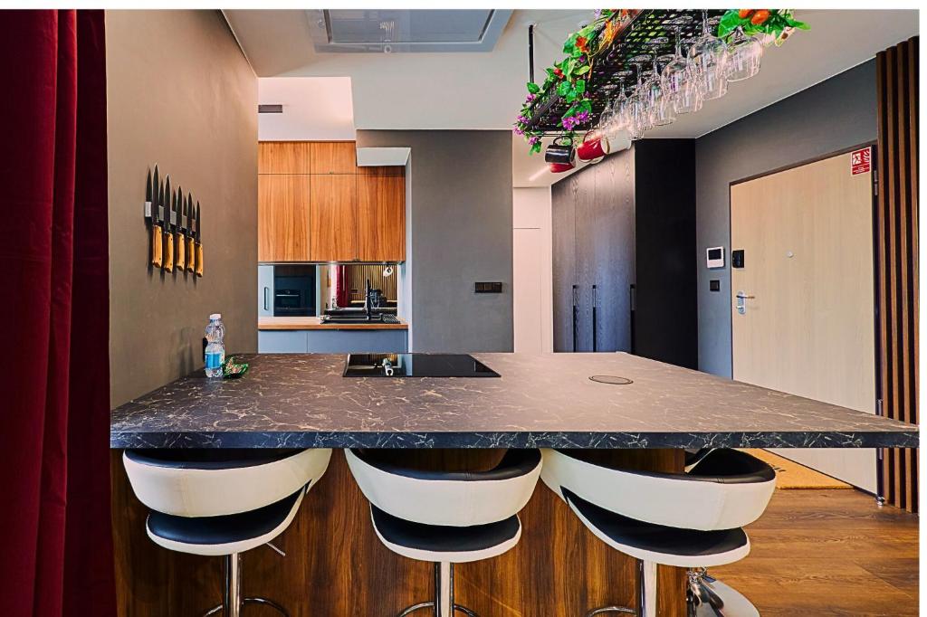 Oceanview Apartment baltyk Gdynia -Bezpłatny parking في غدينيا: مطبخ مع كونتر مع الكراسي حوله