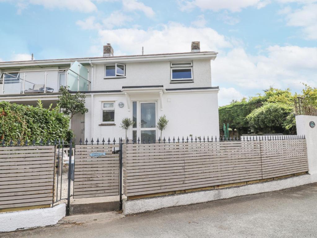 a white house with a wooden fence at Thurlestone, 1 Island View in Kingsbridge