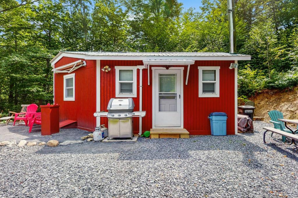 Sugarbush VillageにあるTiny House at Mt Ellenの前にグリルがある赤い小さな家