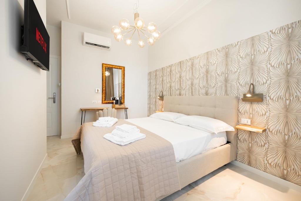 a bedroom with a white bed and a tv at Avenue Suites in Bologna