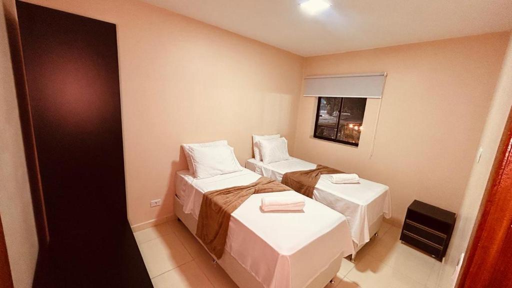 a small room with two beds and a window at Flat Residencial dos Anjos in Maceió