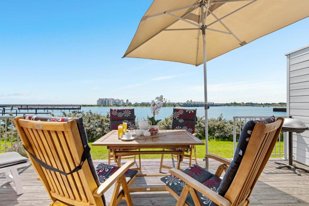 eine Terrasse mit Tisch und Stühlen und einem Sonnenschirm in der Unterkunft Pamir in Kappeln