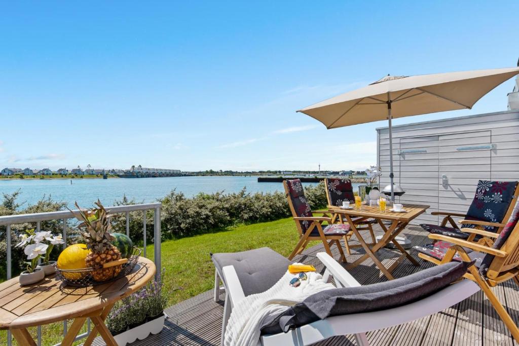 a patio with a table and chairs and an umbrella at Pamir in Kappeln