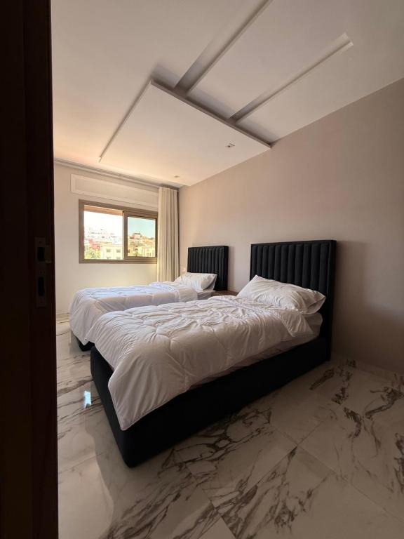 a bedroom with two beds with white sheets at Residence Plaza de Toros in Tangier
