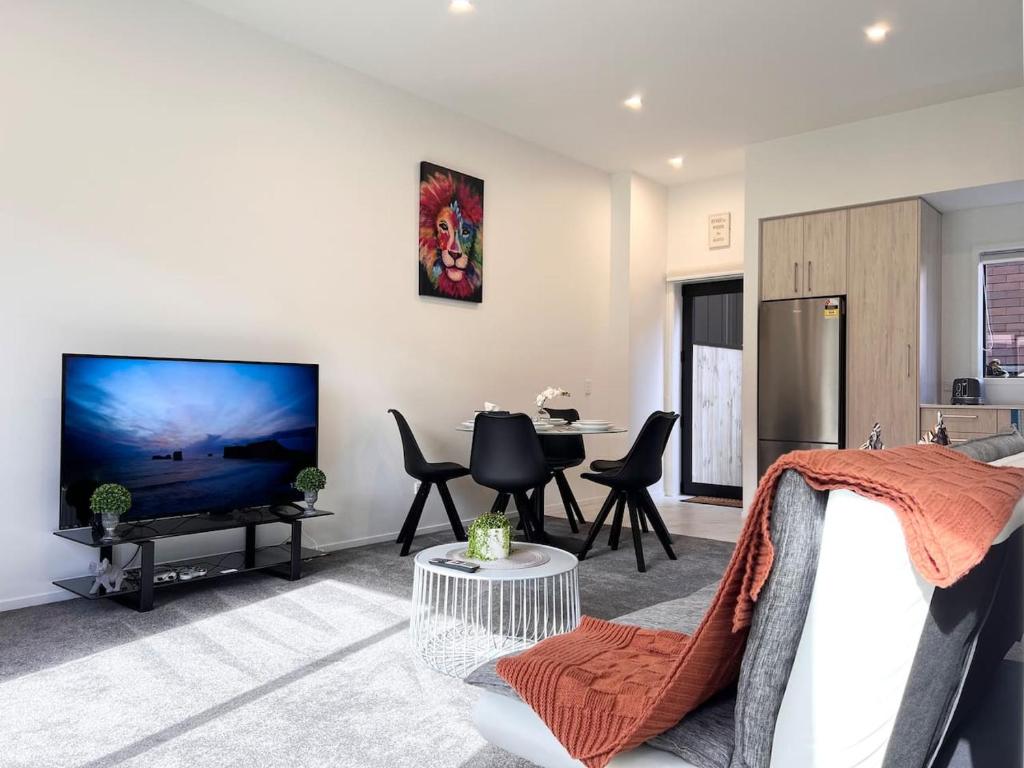 un soggiorno con una grande TV a schermo piatto di Spacious luxe 3 story townhouse on Cashel street a Christchurch