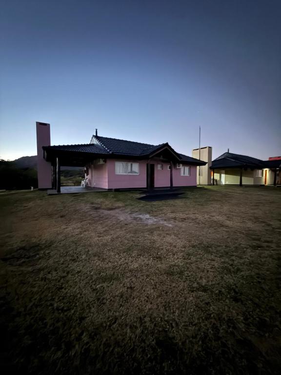 una casa rosa en un campo con un patio en Takua del Lago, en Potrero de los Funes