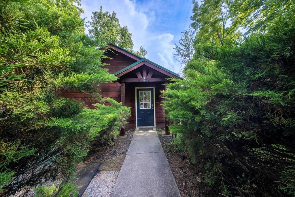 a log cabin with a door between two trees at Couples Getaway Hot Tub & Mountain View in Sevierville