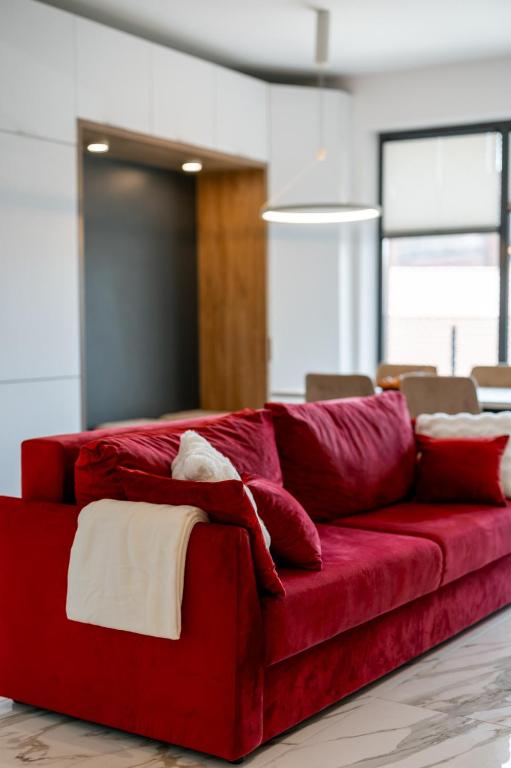 a red couch with pillows in a living room at Elegance Rezidence in Arad