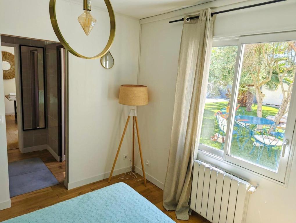 une chambre avec une grande fenêtre et une lampe dans l'établissement Chez Tom et nina, à Lagord