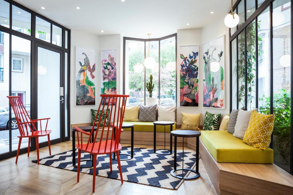 uma sala de estar com cadeiras vermelhas e um sofá amarelo em ibis Styles Paris Nation Porte De Montreuil em Paris
