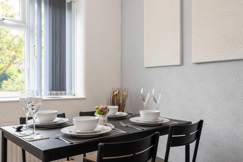 a dining room table with chairs and a black table and chairsktop at Bright and Modern 2 Bed Home w Garden in Liverpool in Liverpool