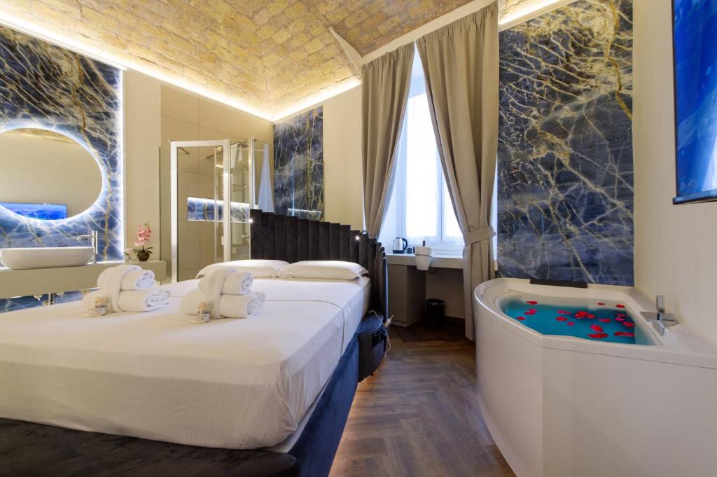 ein Hotelzimmer mit 2 Betten und einer Badewanne in der Unterkunft Antinous Suites in Rom