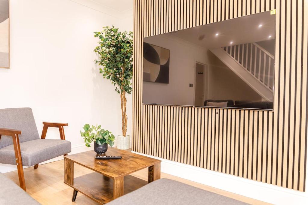Una sala de estar con un gran espejo en la pared. en 3BR Modern Stay - Wi-Fi & Parking, en Monkwearmouth