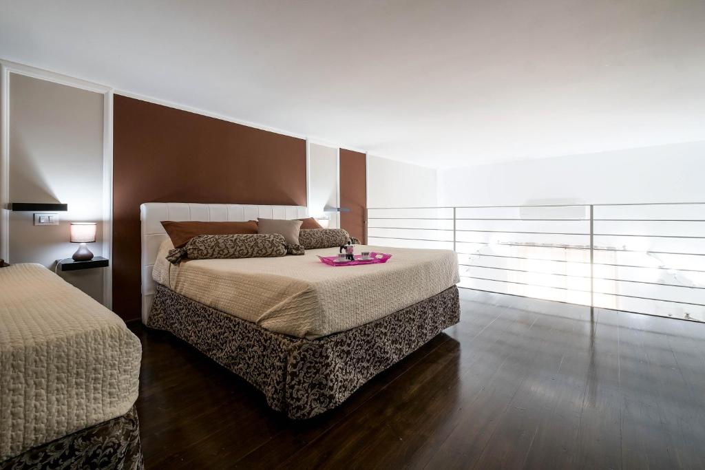 ein Schlafzimmer mit einem Bett mit einem rosa Tablett darauf in der Unterkunft Quattro Canti Apartments in Palermo