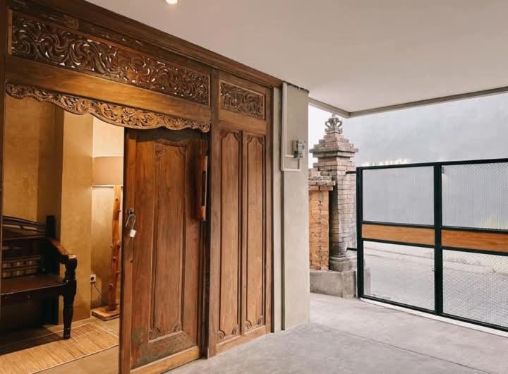 an entrance to a house with a wooden door at Victory Beloved House Sanur Private Rooms Villa Bali in Sanur