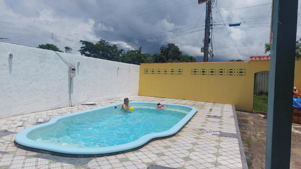 two children playing in a pool in a backyard at Casa COP 30 BELÉM-Mosqueiro in Belém